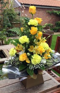 Boxed bouquet of yellow roses and carnations