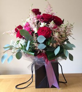 Boxed bouquet of red roses and eucalyptus