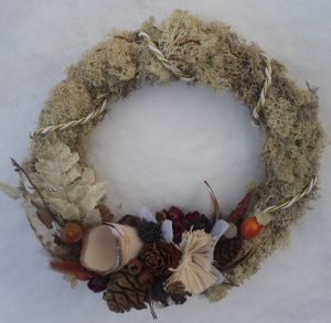 Moss covered Christmas wreath with pine cones and berries